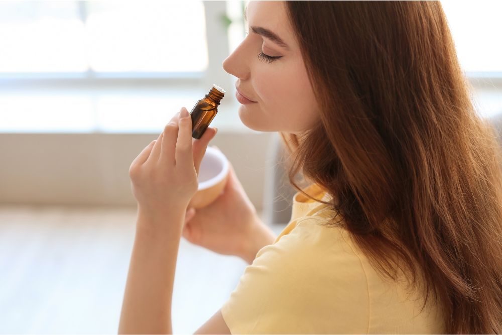 Žena relaxuje s esenciálními oleji a difuzérem v útulném prostředí