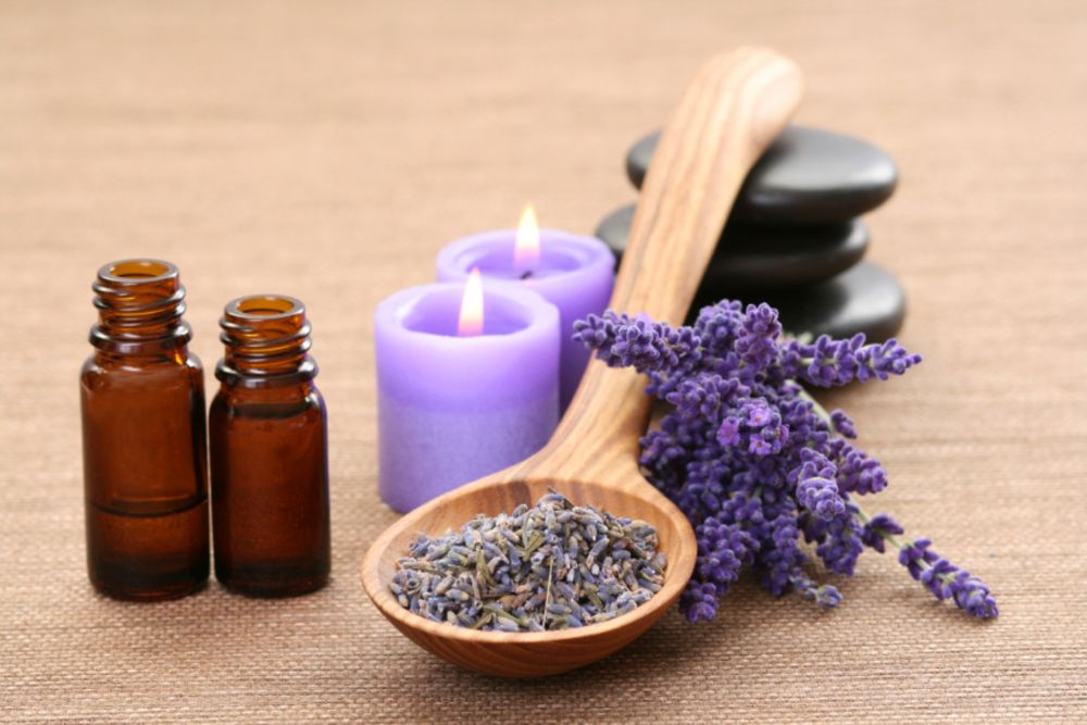 Aromaterapeutické směsi esenciálních olejů v miskách s květinami