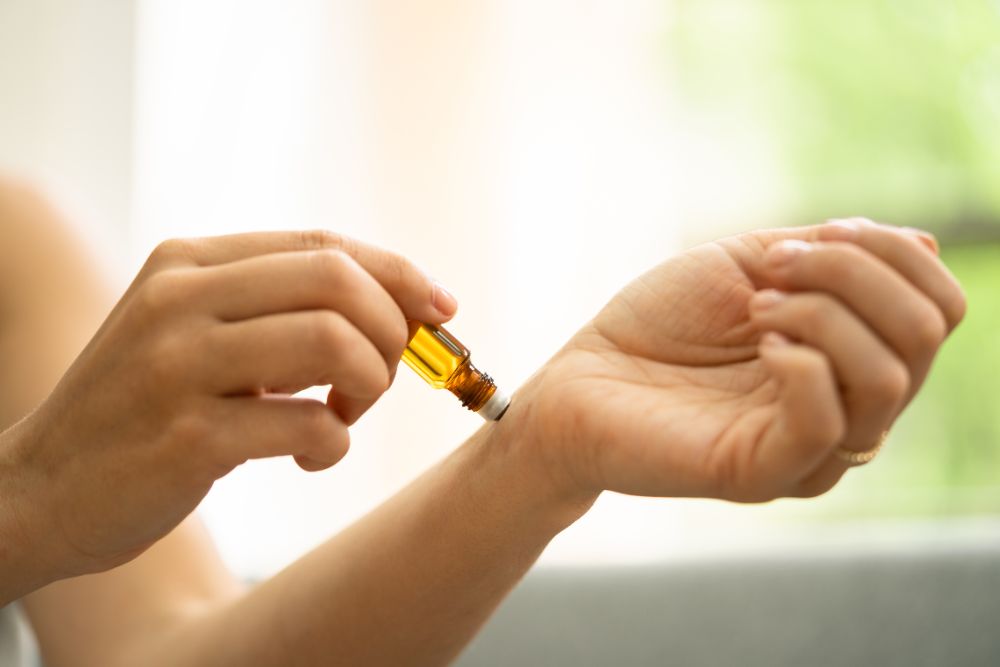 Nanášení esenciálního oleje na zápěstí – ukázka bezpečného použití aromaterapie v domácím prostředí.